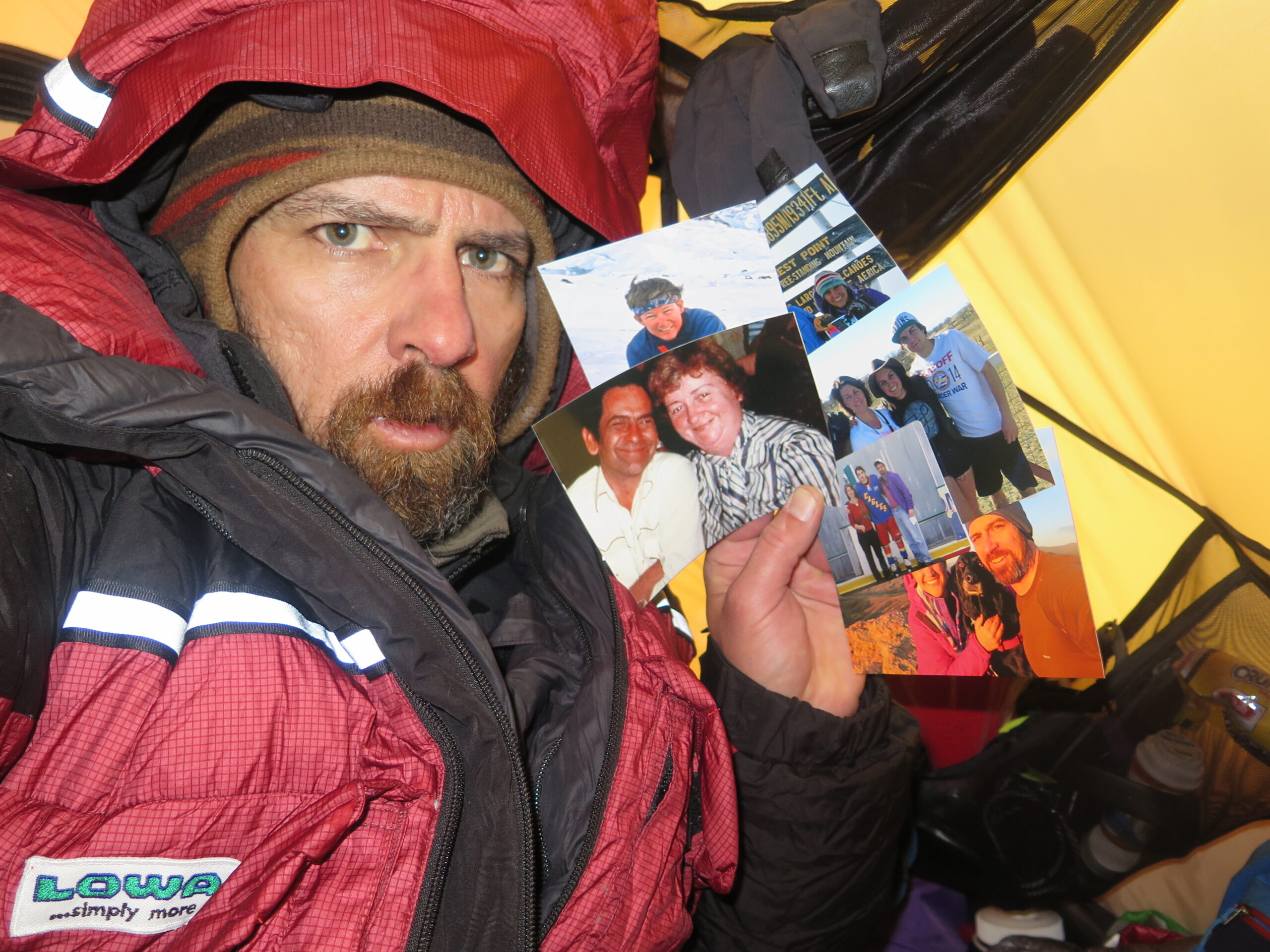 Jim Davidson holding pictures of his loved ones, while stuck on Everest (copyright speakingofadventure.com)